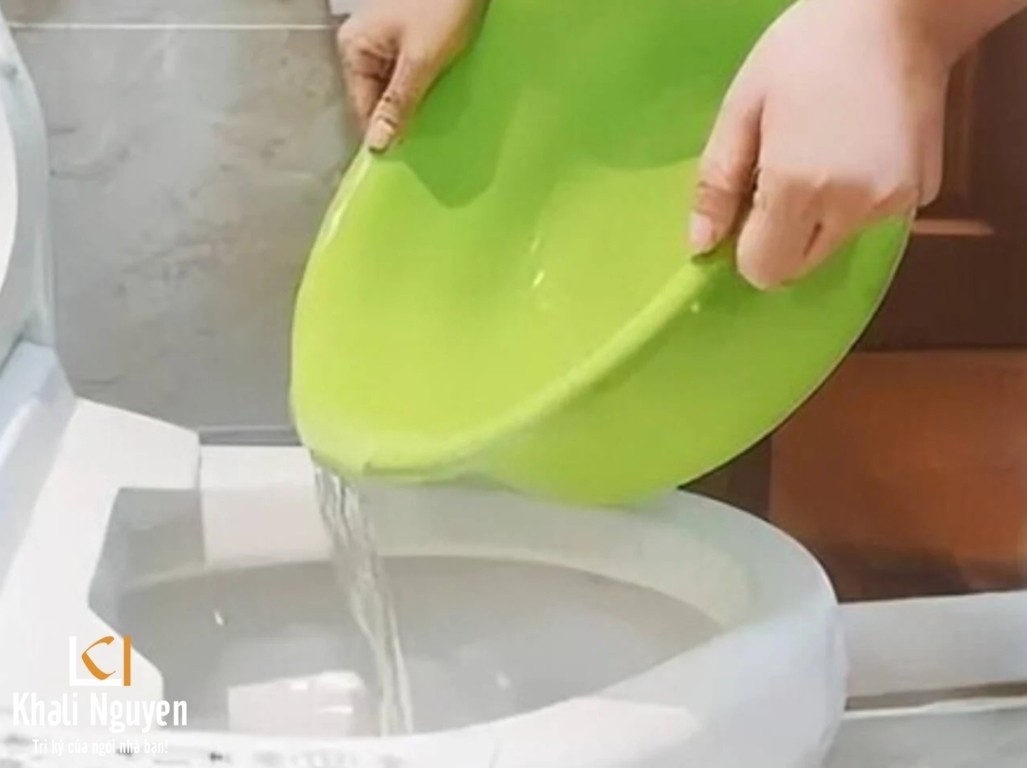 Ảnh Đổ nước vào bồn cầu để xả
